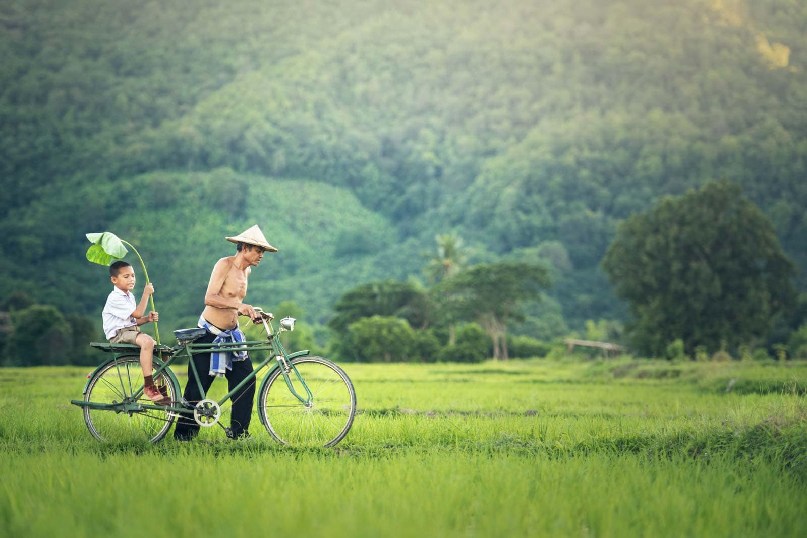 Cambodian Child and Father on Bike in green Nature